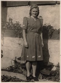 Junge Frau mit selbstgenähten und mit Enzianblüten bestickten Kleid