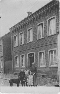 Mutter mit drei Kinder und Hund vor ihrem Wohnhaus